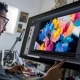 A photo of a graphic designer working on a colorful project on a large monitor