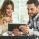 Close up portrait of happy young couple using a digital tablet together at a coffee shop
